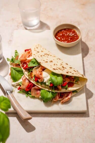 Une recette de piadina au jambon cru. Piadina italienne garnie avec poivrons, roquette, mozzarella & jambon cru.